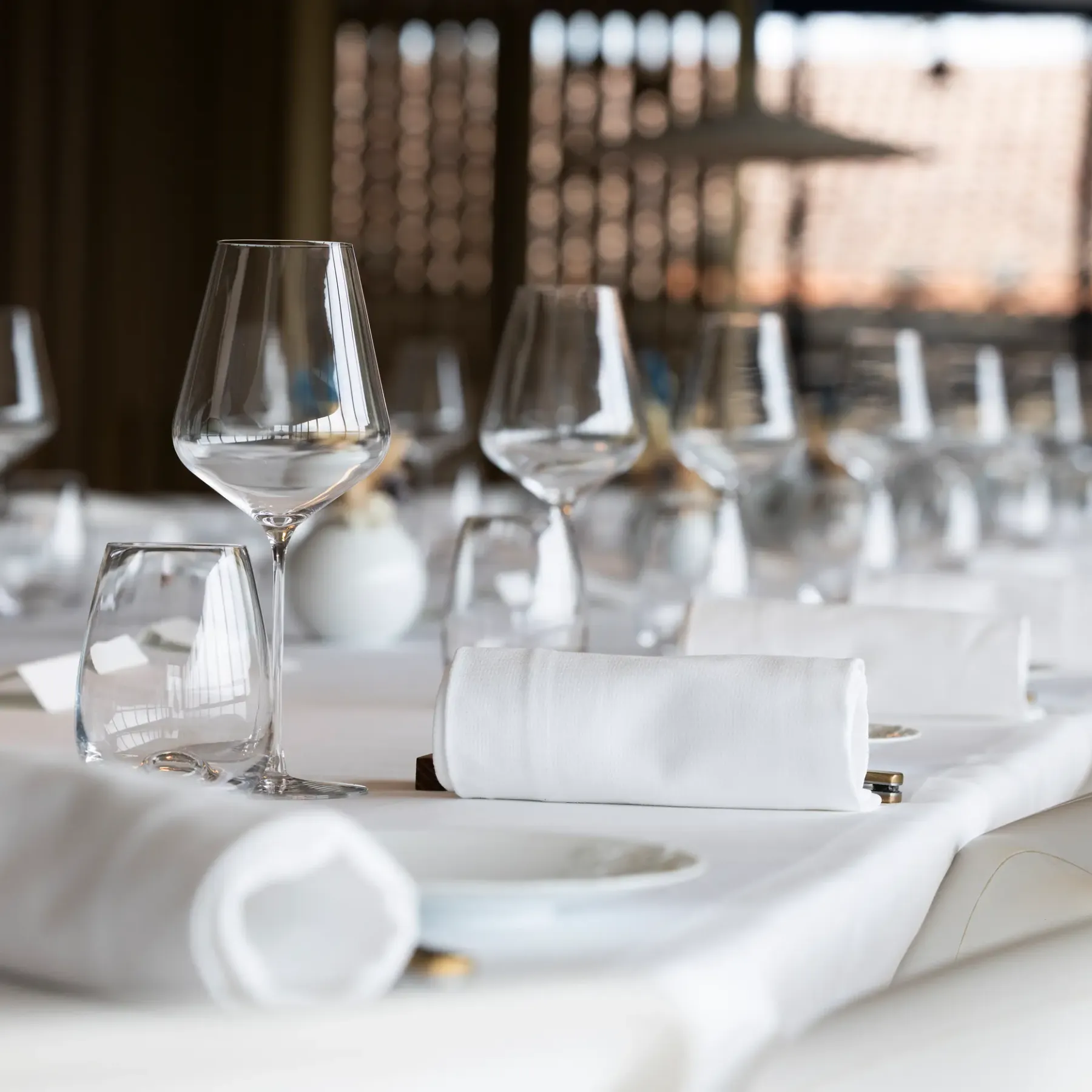 Table dressée avec des verres à vin, des serviettes et des assiettes, vue en plan rapproché