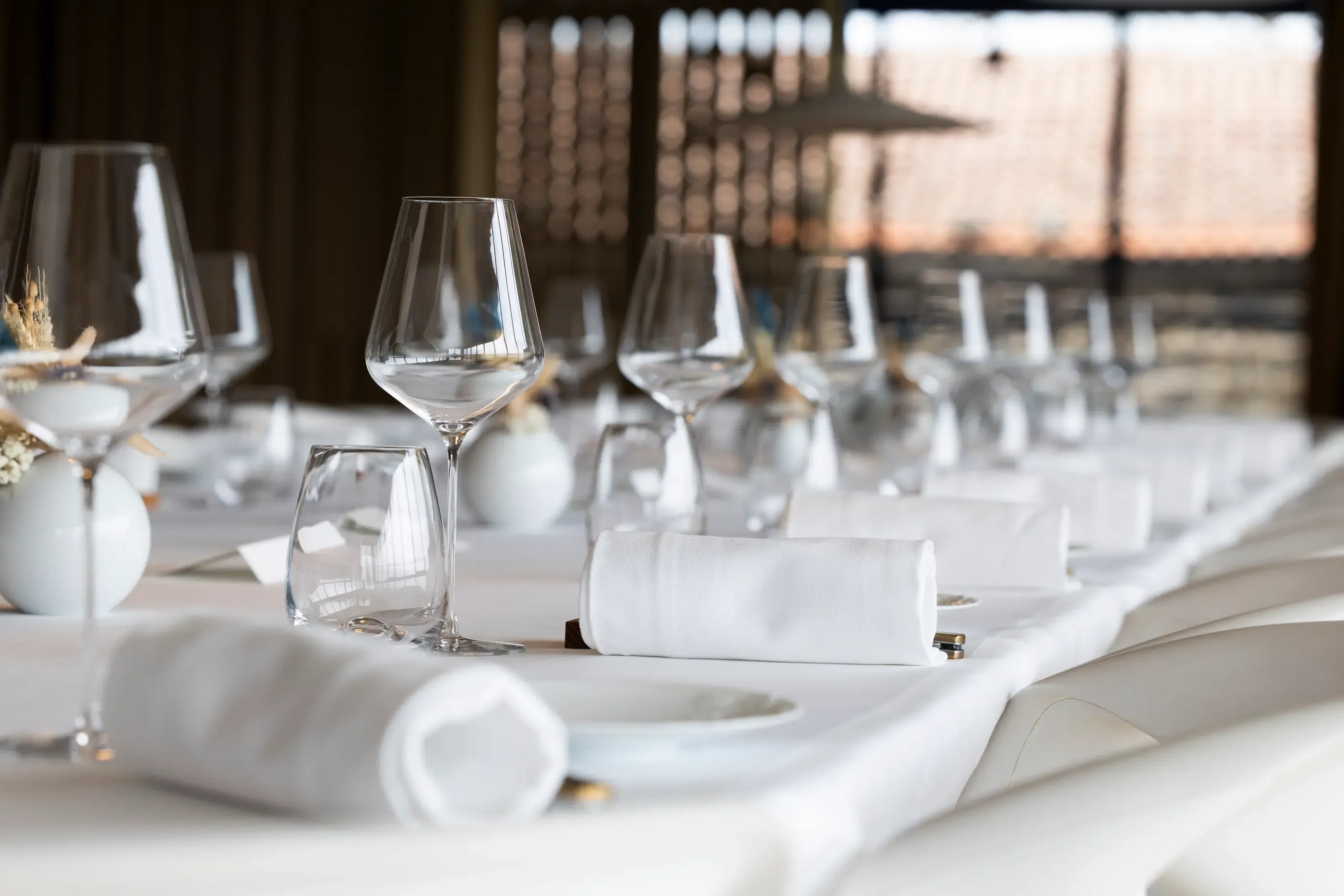 Table dressée avec des verres à vin, des serviettes et des assiettes, vue en plan rapproché